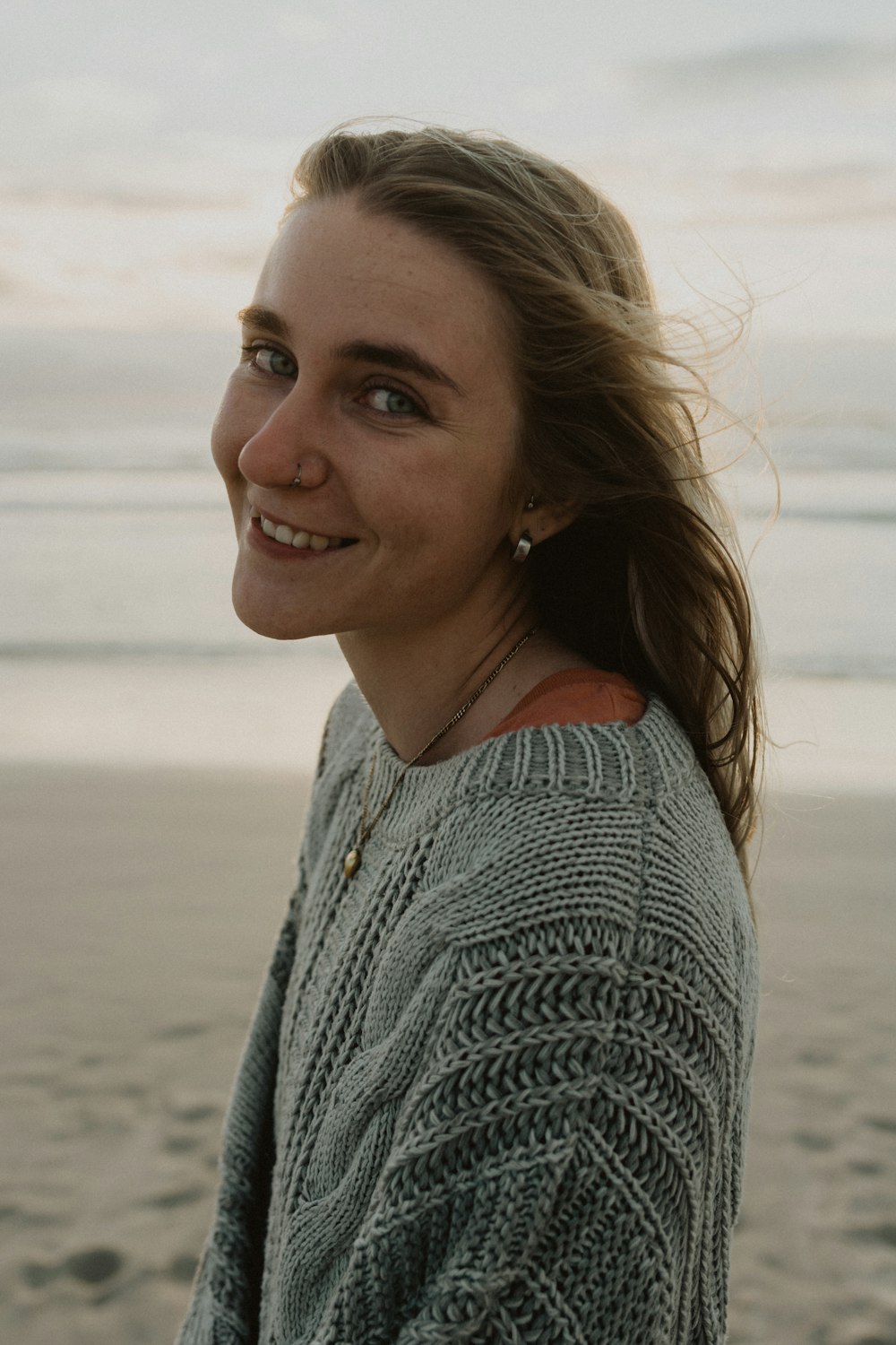 Mujer en suéter de punto gris sonriendo
