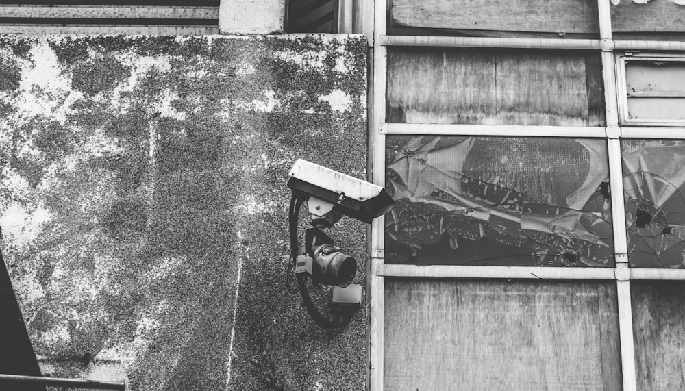 black and white photo of a camera on a window