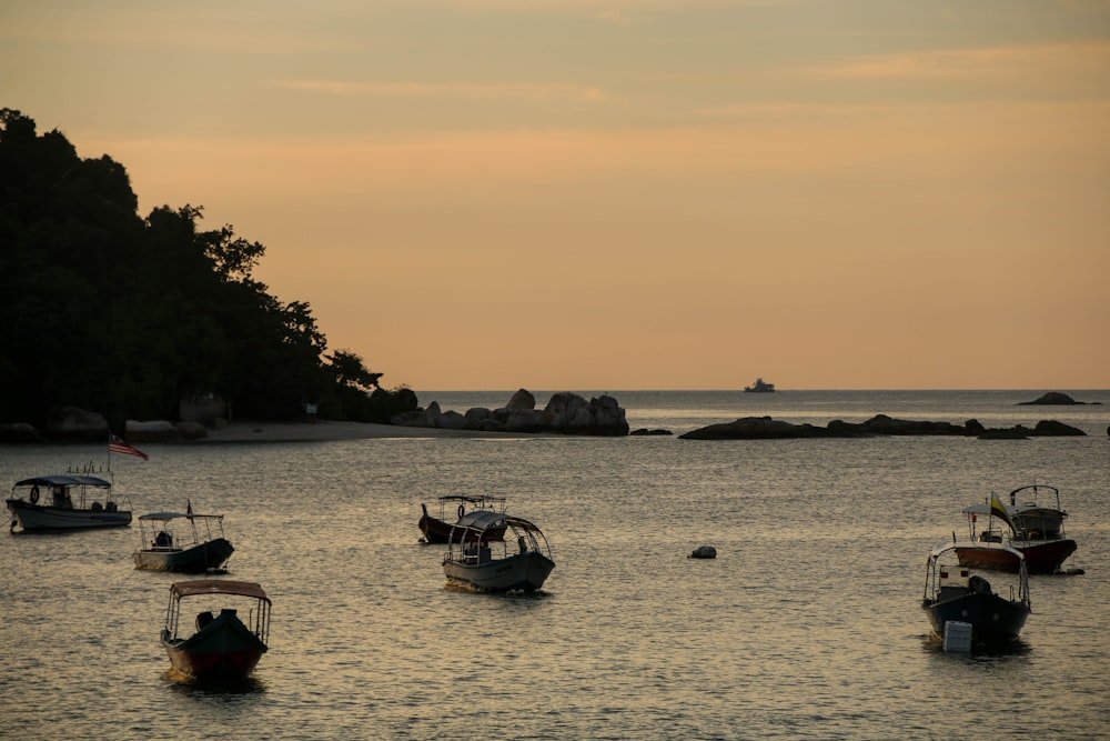 Silueta de personas que montan en barco en el mar durante la puesta del sol