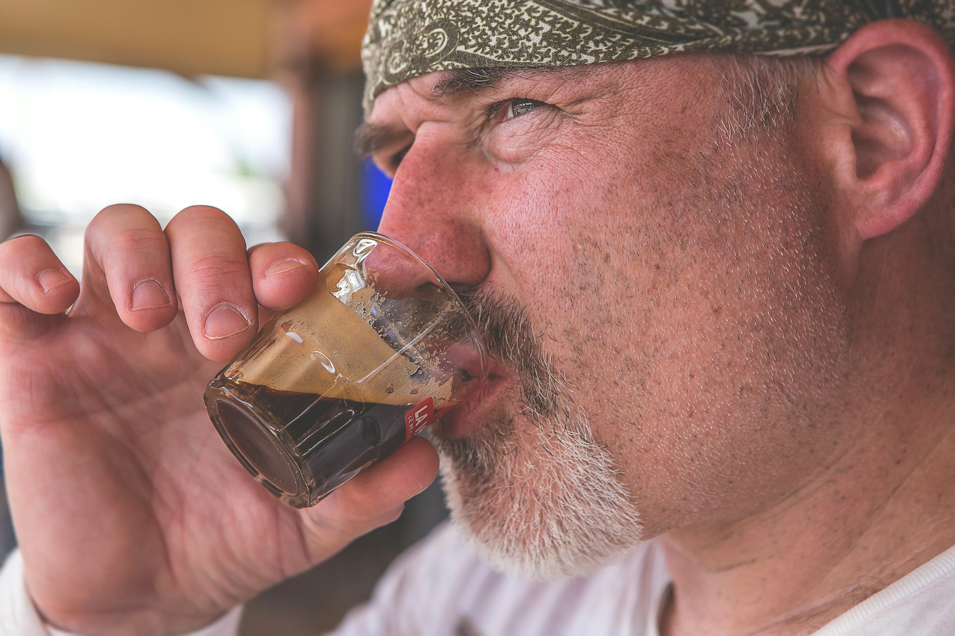 A whimsical illustration of a bearded man enjoying a cup of coffee in a cozy café.