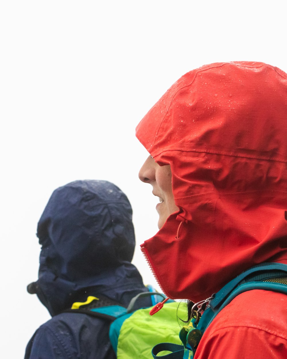 hombre con sudadera con capucha roja al lado de hombre con sudadera con capucha negra