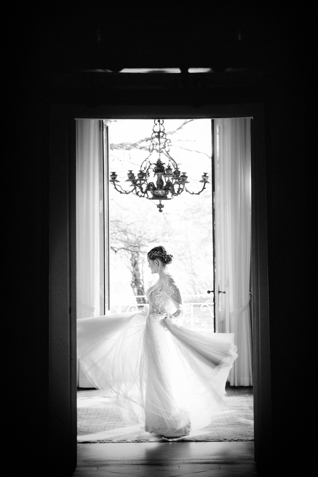 woman in white wedding dress standing near window