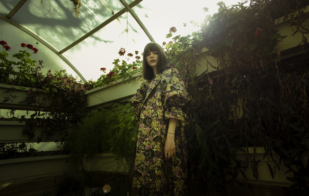 woman in green and white floral robe standing near green plants during daytime