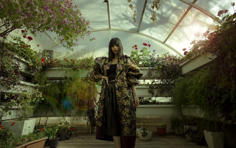 woman in black and white floral dress standing near flowers