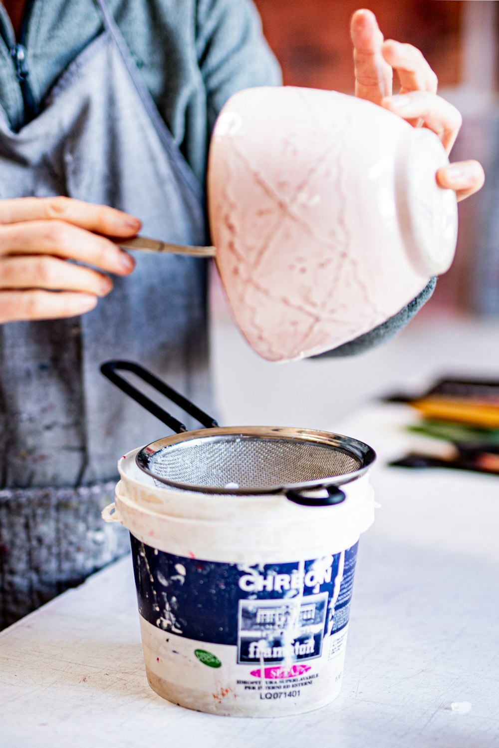 persona sosteniendo una taza blanca y azul con helado