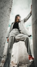 woman in gray coat sitting on concrete bench