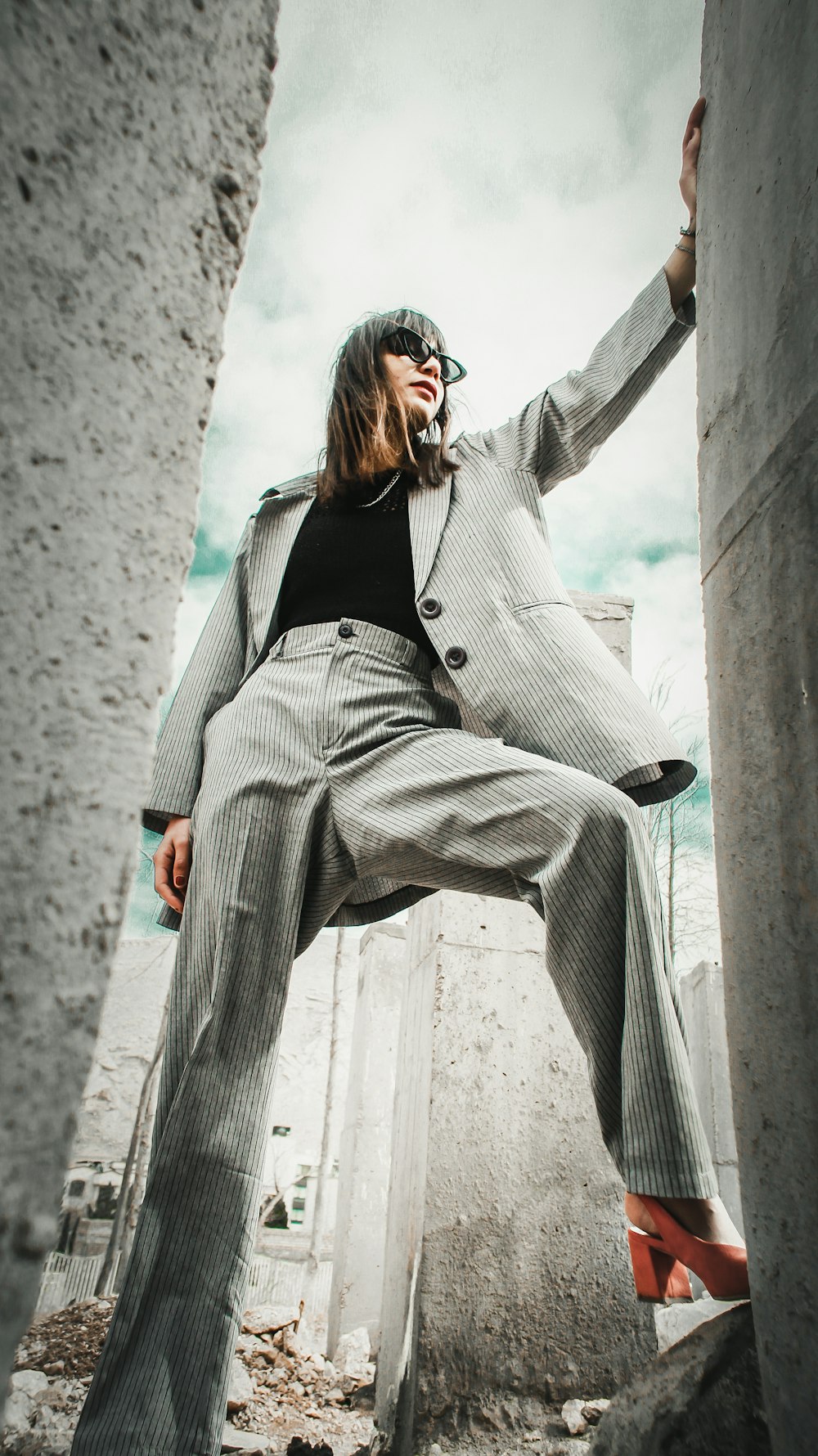 woman in gray coat sitting on concrete bench