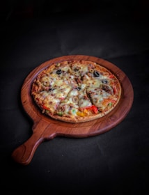 pizza on brown wooden round tray