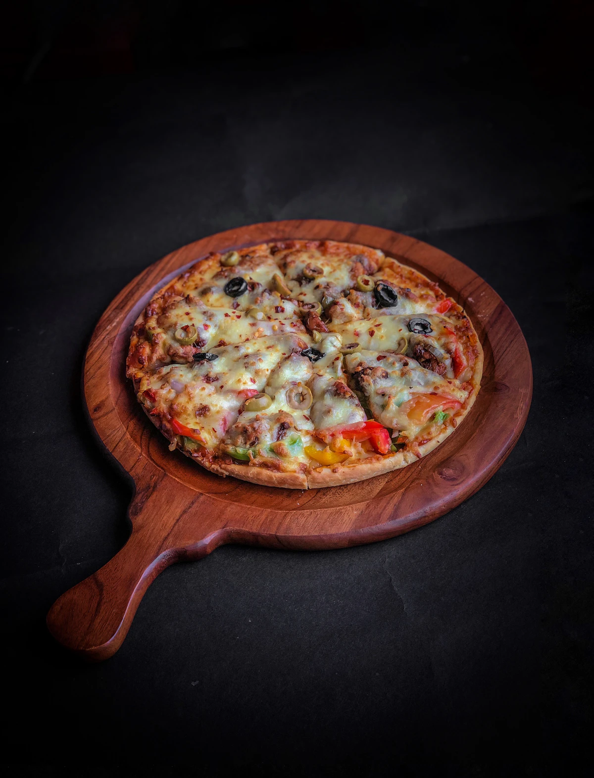 A pizza being lifted from the peel, blistered at the edges