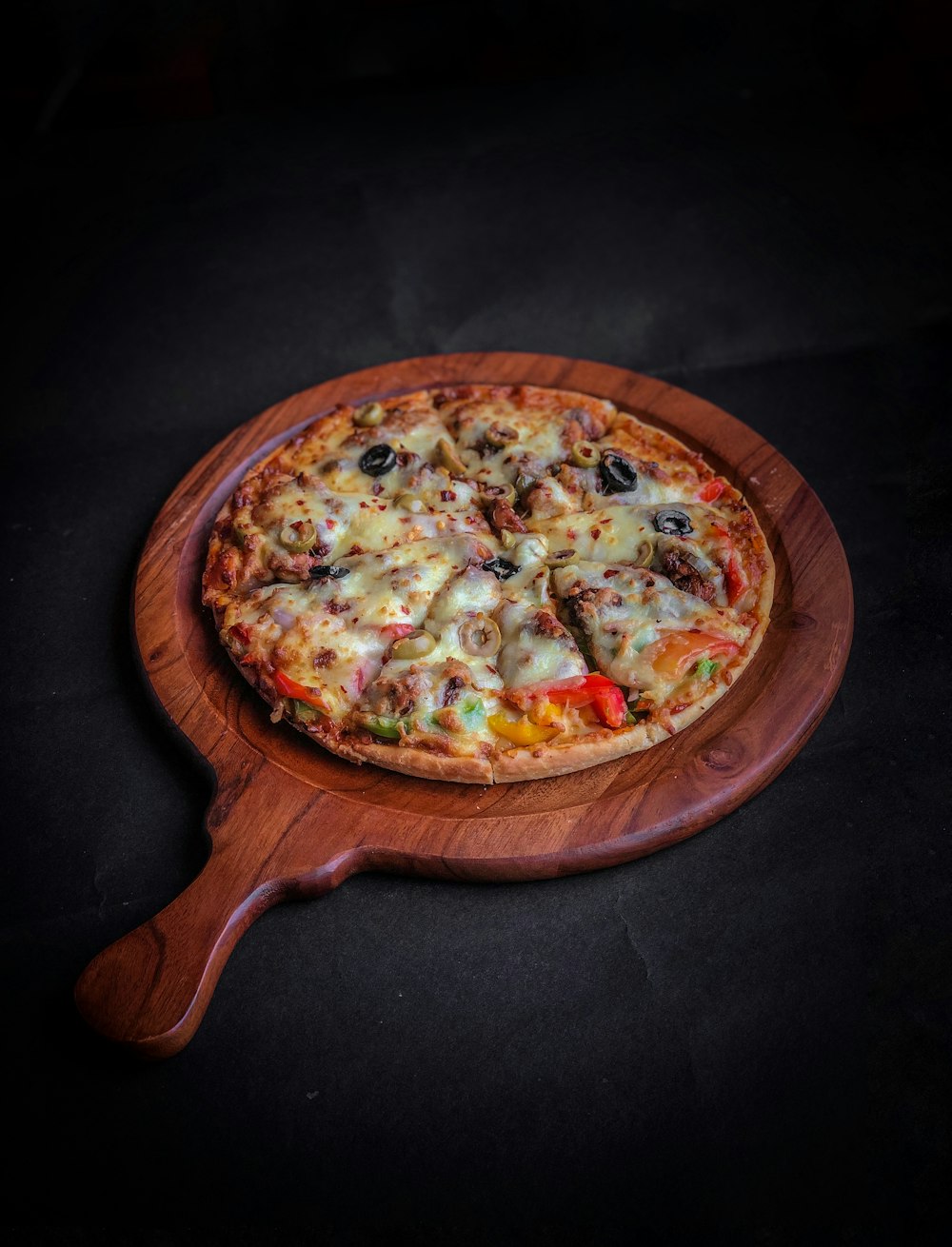 pizza on brown wooden round tray