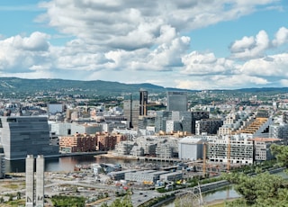 city buildings under white clouds and blue sky during daytime