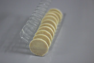 Rows of transparent packaging trays neatly arranged on a clean white factory surface.