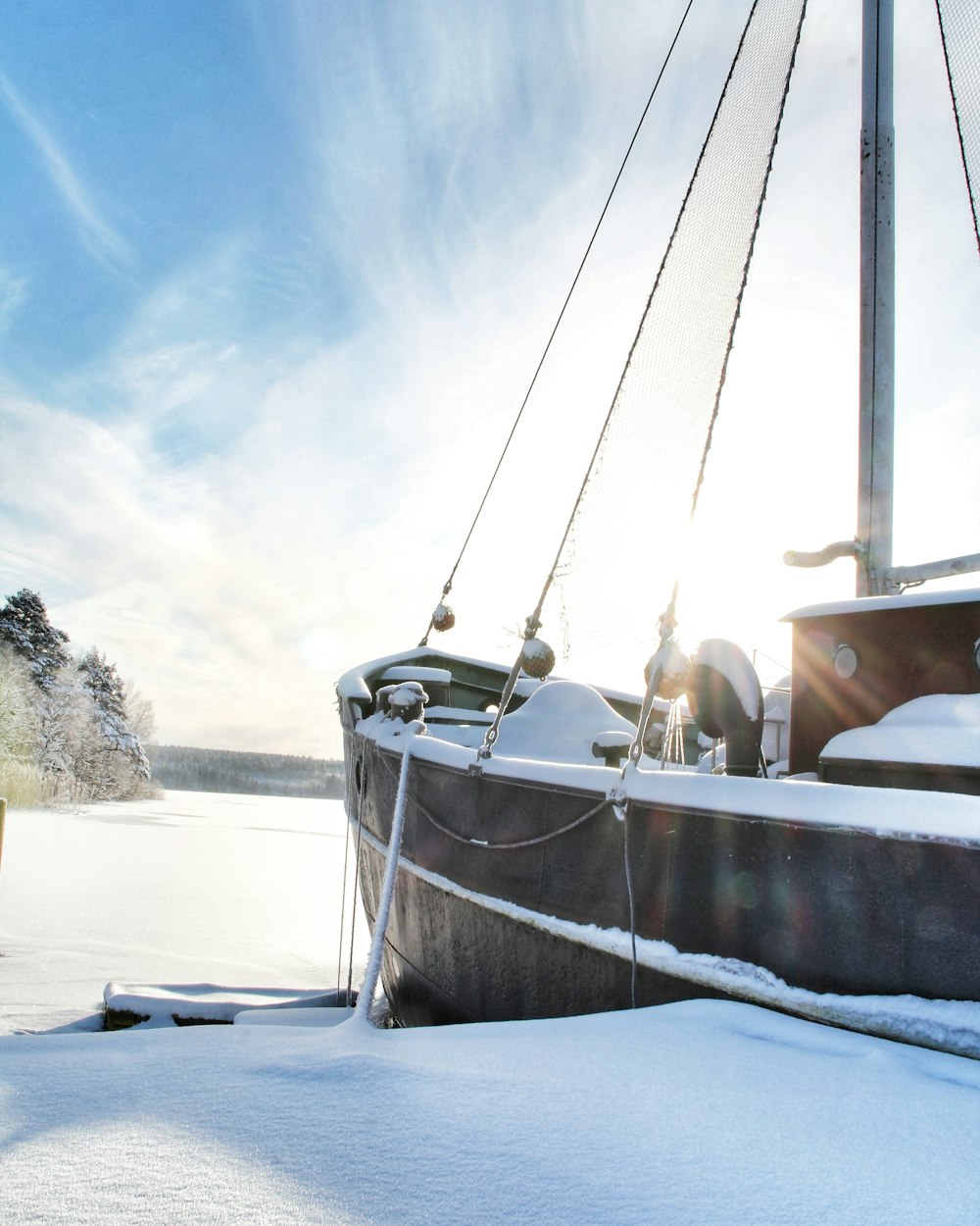Barco blanco y marrón en suelo cubierto de nieve durante el día