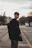 man in black coat standing on road during daytime