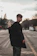 man in black coat standing on road during daytime