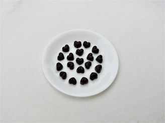 Selection of colorful French chocolates arranged in a flower shape on a white ceramic plate