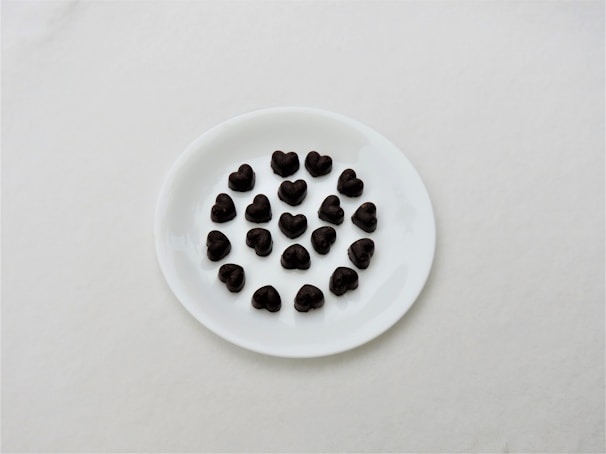 Selection of colorful French chocolates arranged in a flower shape on a white ceramic plate