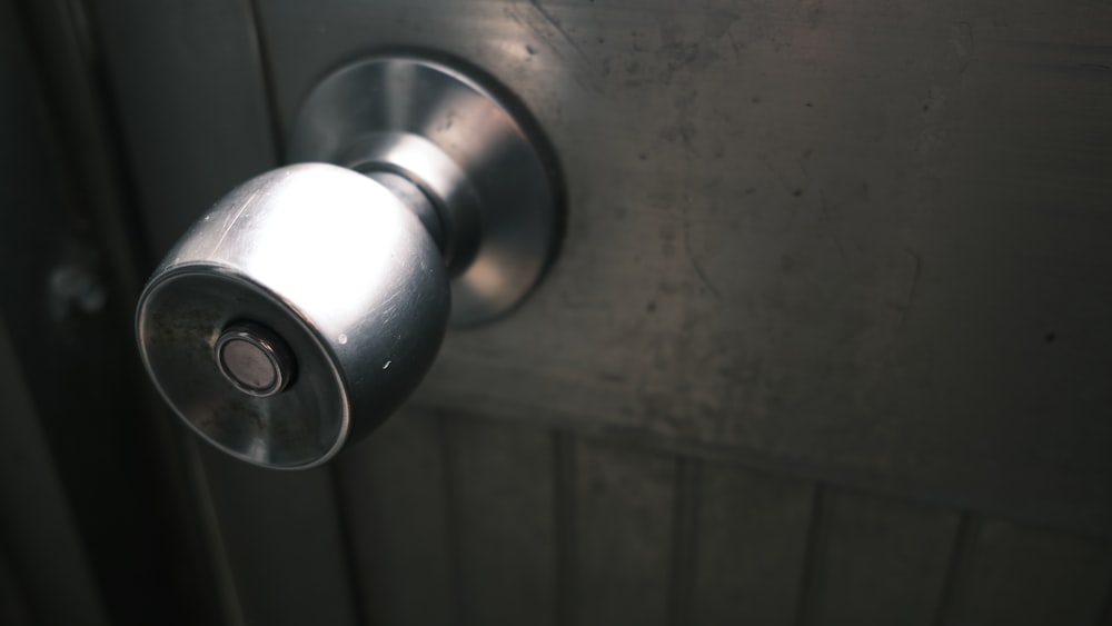 stainless steel door knob on white wooden door