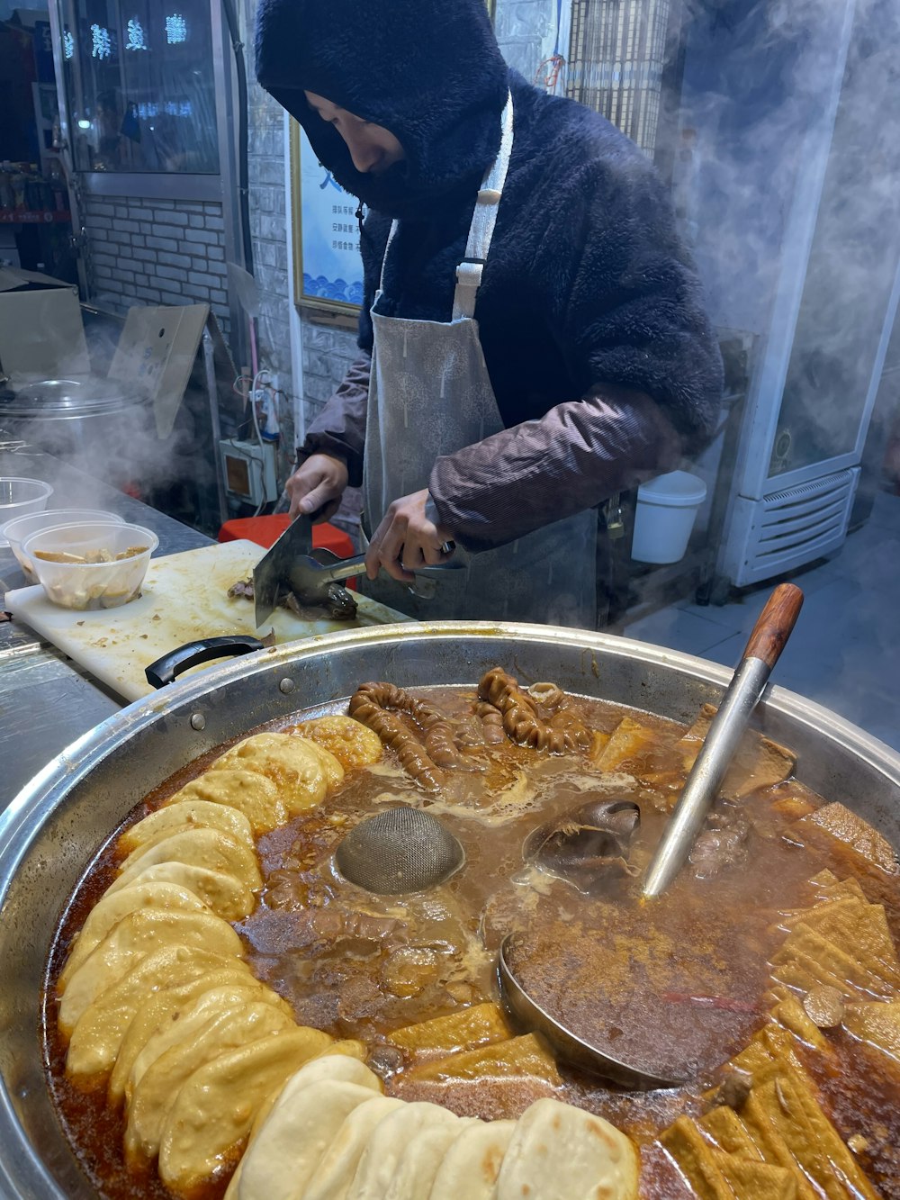 person in black and red jacket cooking food