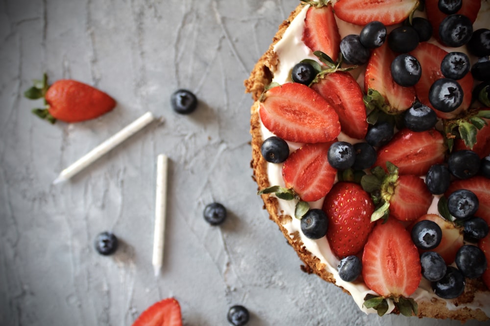 sliced strawberries and blueberries on white ceramic plate