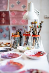 Pinceaux dans des bocaux assiette pleine de peinture dans un atelier d'artiste