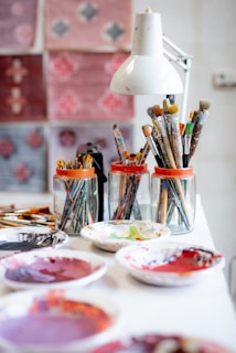 Pinceaux dans des bocaux assiette pleine de peinture dans un atelier d'artiste