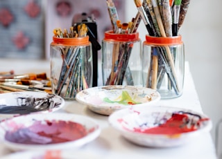 white ceramic plate with paint brushes and paint brushes