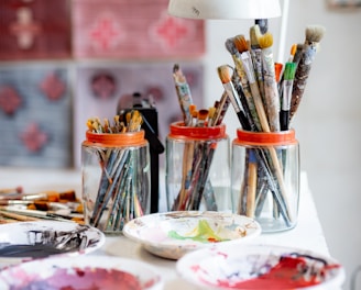 white ceramic plate with paint brushes and paint brushes