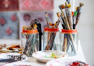 white ceramic plate with paint brushes and paint brushes