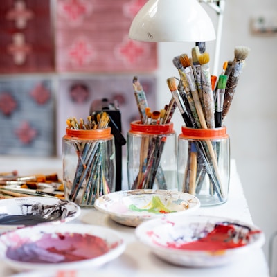 white ceramic plate with paint brushes and paint brushes