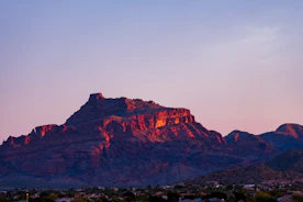 A powerful controlled explosion in a rocky mountainous terrain at dawn.