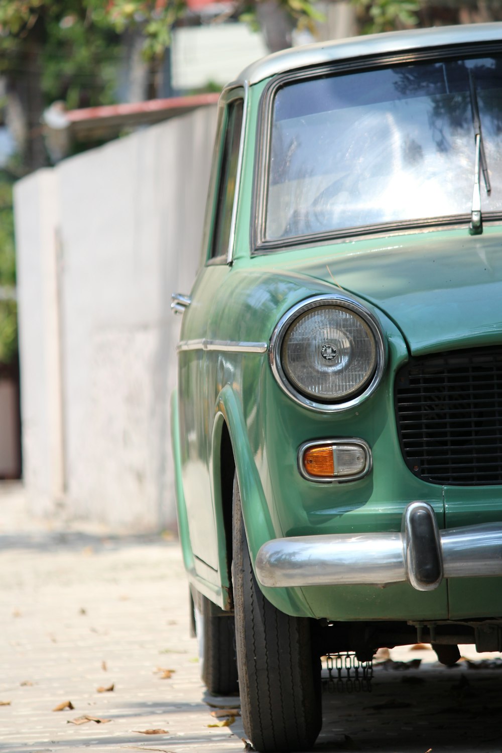 green car on gray concrete road during daytime