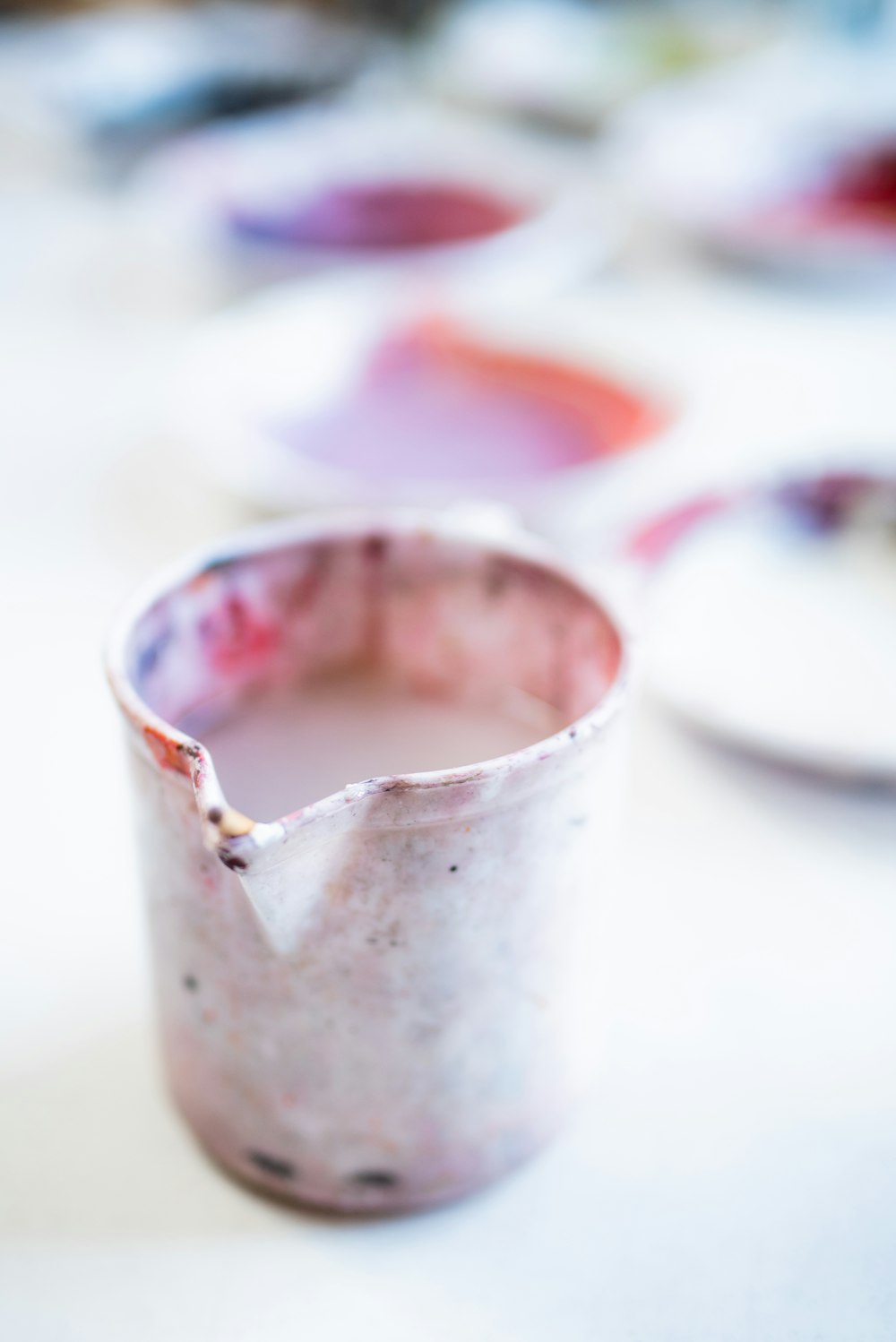 white and red ceramic mug on white table