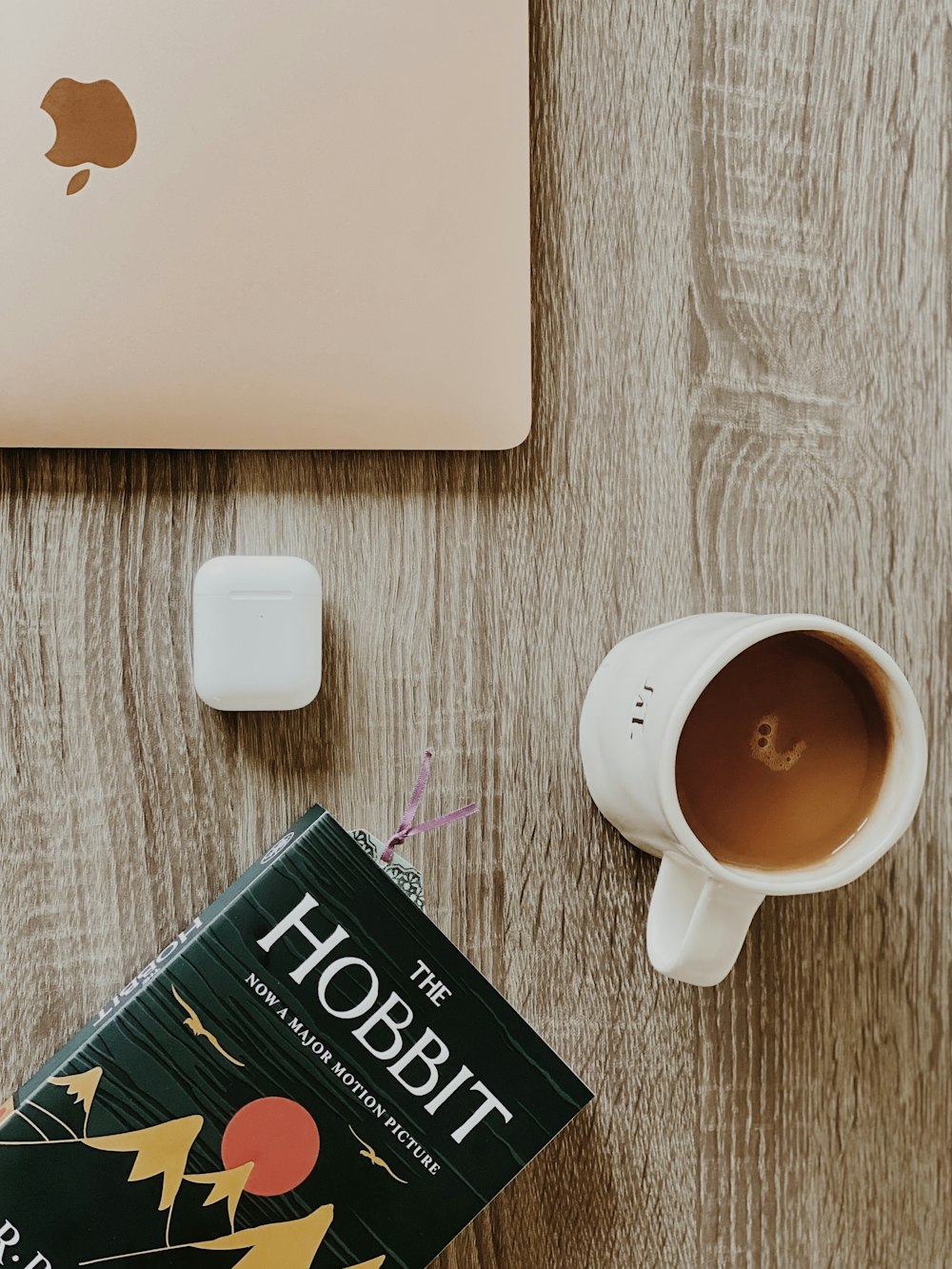 Taza de cerámica blanca al lado de la computadora portátil blanca