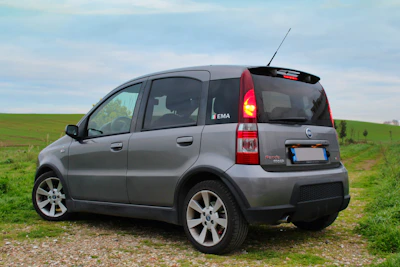 A compact hatchback parked near a beachside promenade.