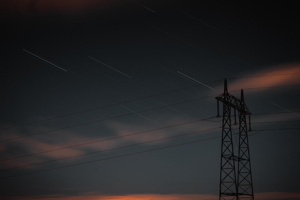 black electric tower under orange sky