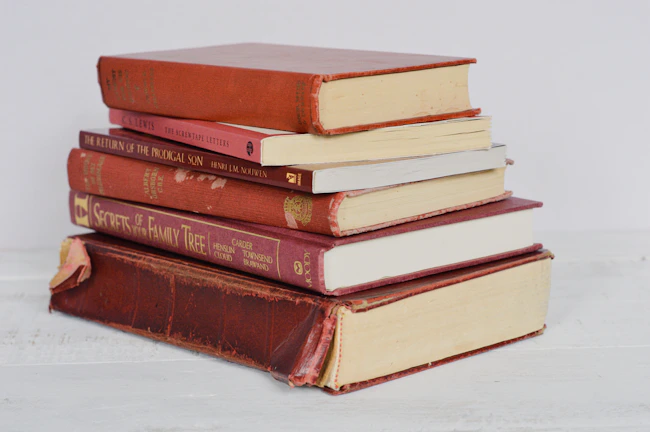Stack of six colorful books arranged neatly on a wooden table.