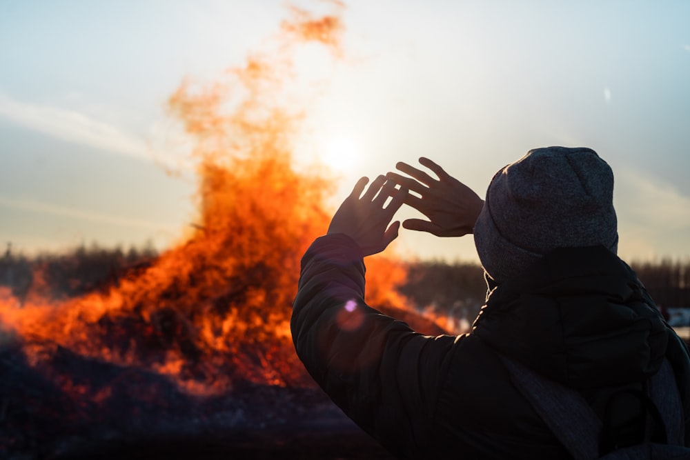 person in black jacket covering face with hands