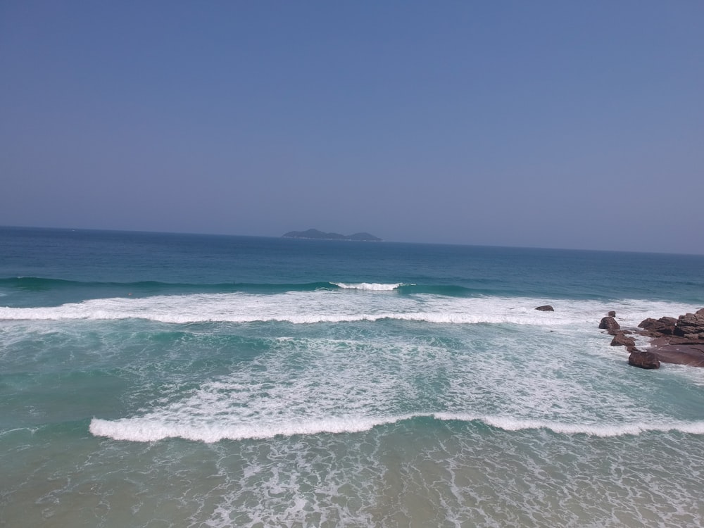 ondas do oceano batendo em terra durante o dia