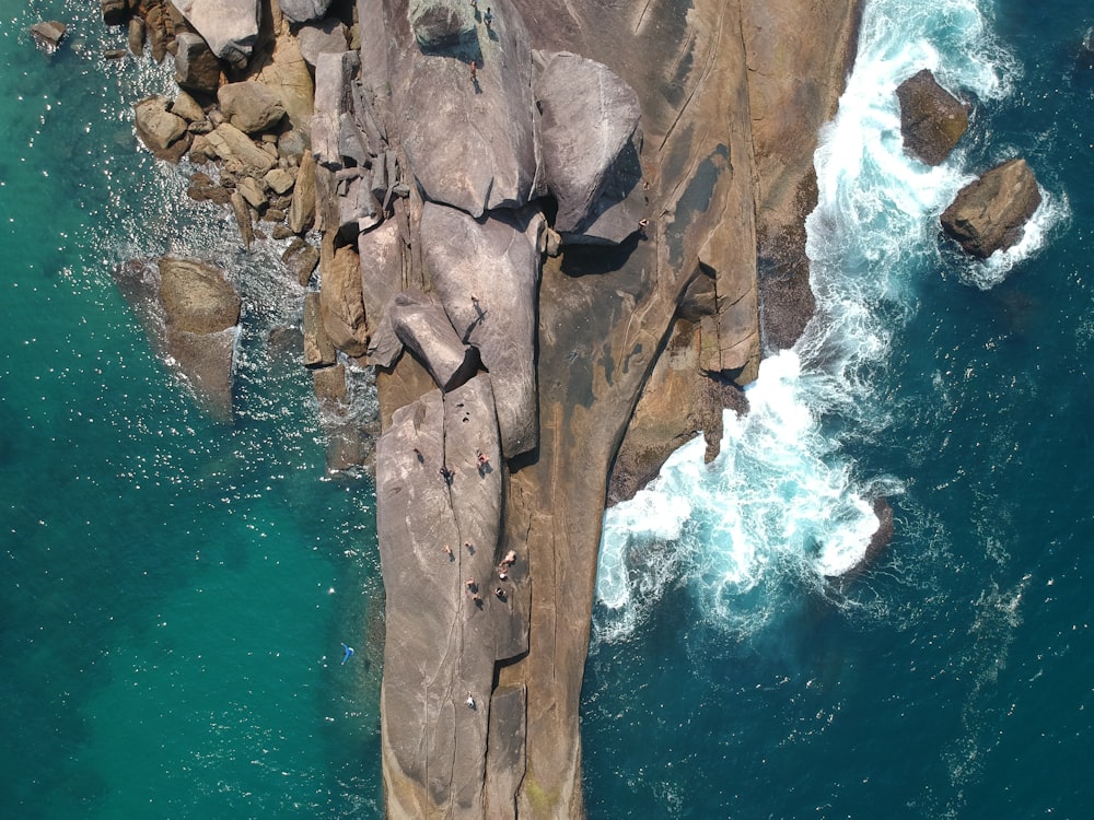 brown rock formation beside body of water during daytime