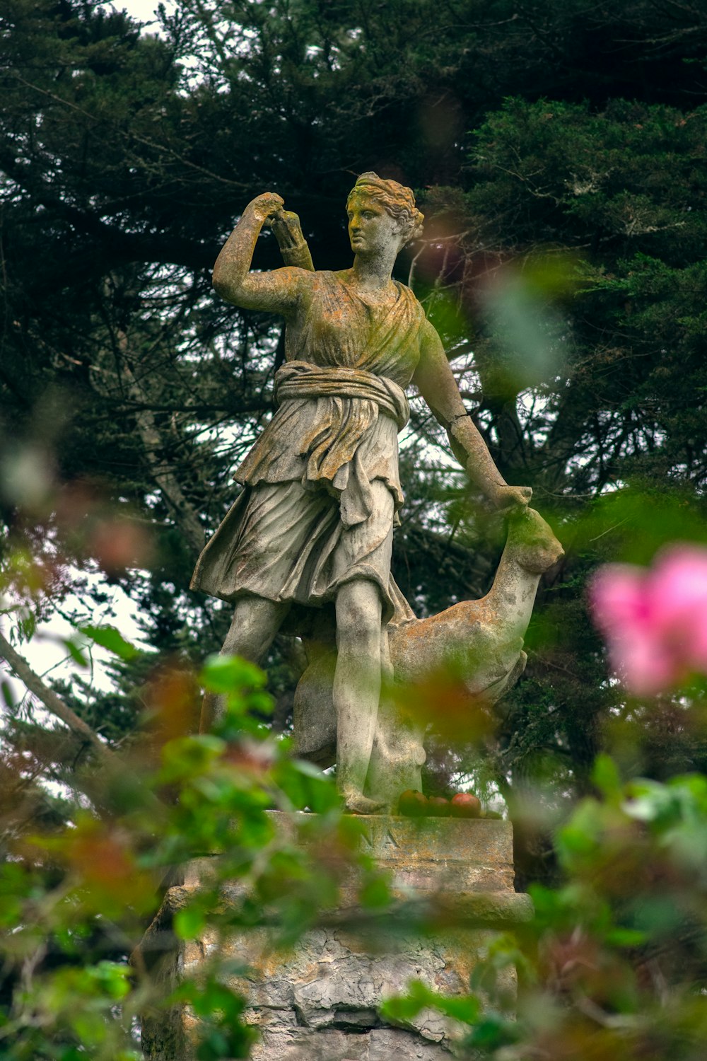 brown statue of man in the middle of forest during daytime