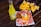 A vibrant scene with a bottle of Jarritos pineapple soda next to a plate of spicy snacks covered in melted cheese and spices, garnished with a lime wedge. In the background, a bowl filled with tortilla chips is visible, all placed on a rustic wooden table.