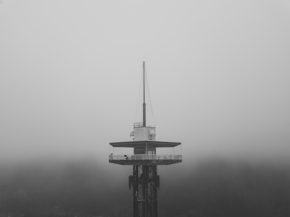 black and white tower in the middle of fog