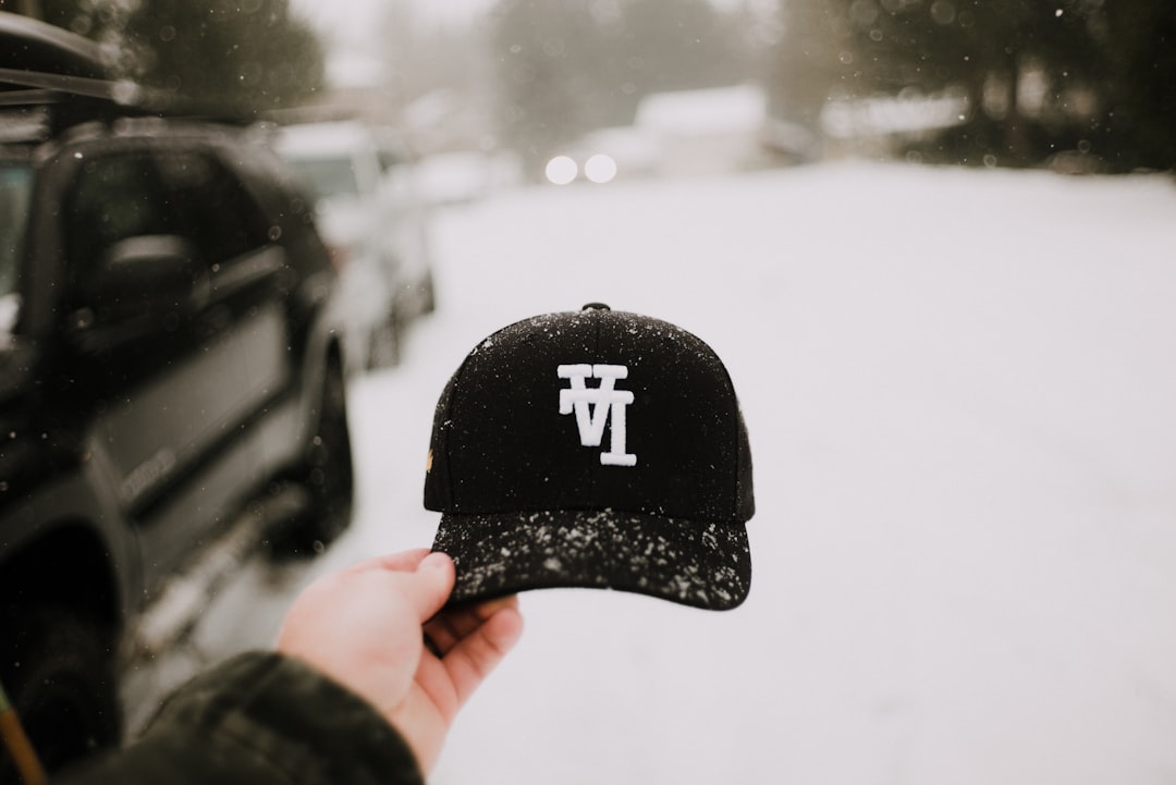 person in black and white fitted cap