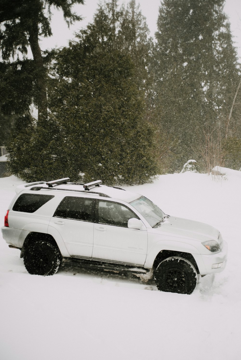 white suv on snow covered ground during daytime