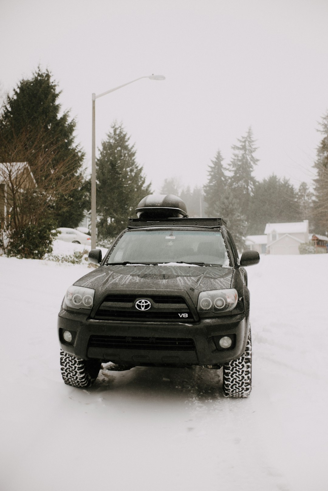 black car on snow covered road during daytime