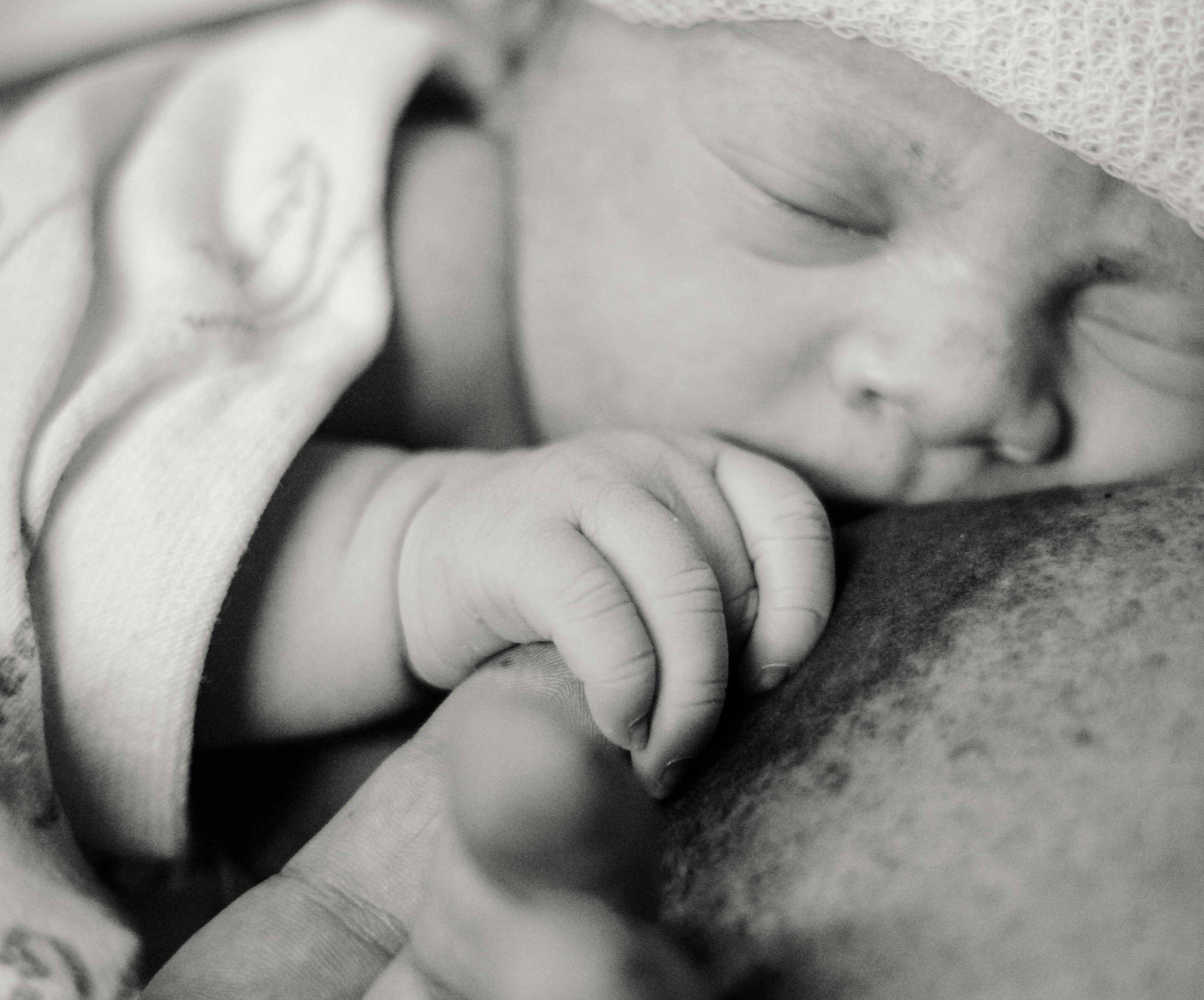 breastfeeding newborn holding parent's finger
