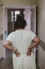 woman in white dress standing near white wall