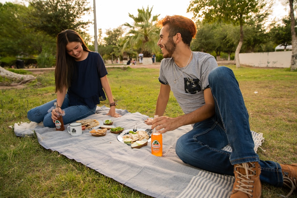 man in gray crew neck t-shirt sitting beside woman in black tank top