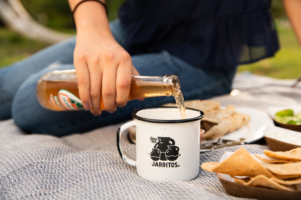 person holding white ceramic mug